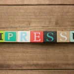 Das Wort "Impressum" in bunten Würfeln dargestellt.