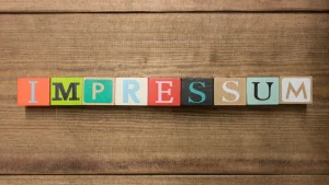 Das Wort "Impressum" in bunten Würfeln dargestellt.